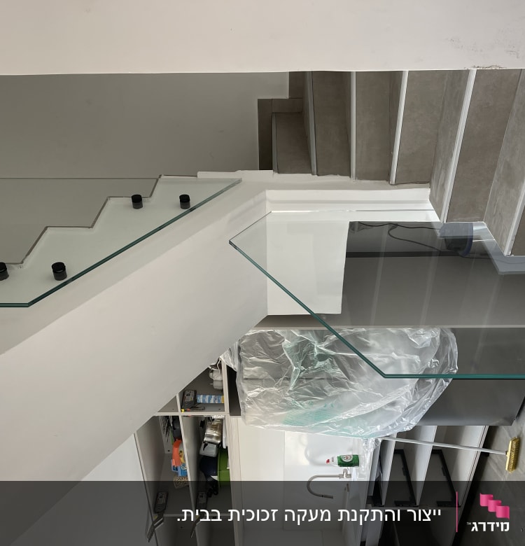 מעקה זכוכית שקוף עם מחברים שחורים על מדרגות